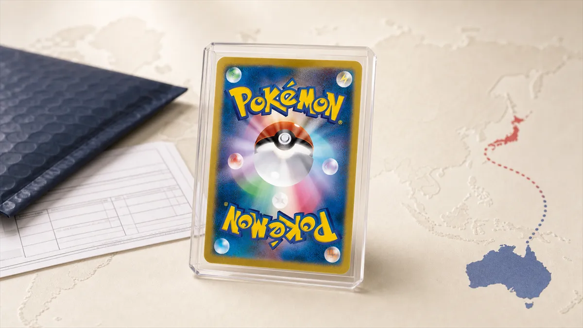 A Japanese Pokémon card, back facing out, standing in a clear protective case on a cream world-map surface, with a dotted route line running from Japan to Australia, beside a navy padded mailer and a blank customs declaration form